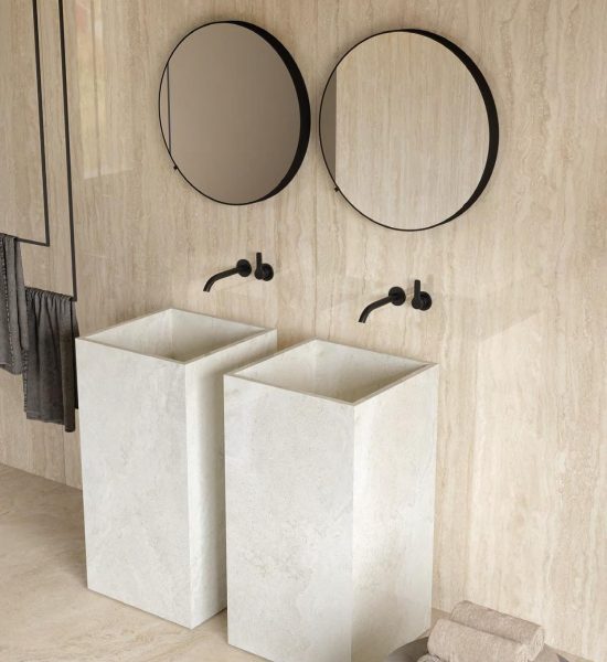 Baño con lavabos exentos, grifería negra y revestimiento efecto piedra