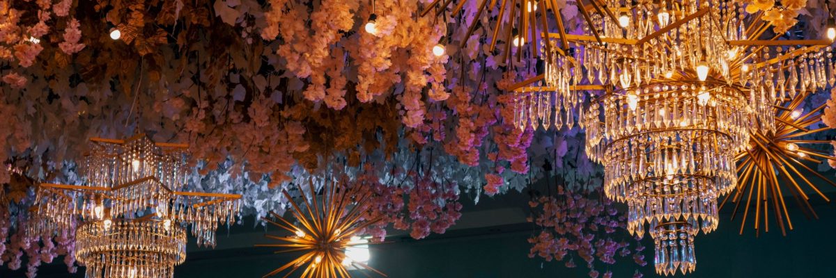 Vista panorámica de candelabros brillantes que cuelgan del techo rodeados de decoraciones florales costa azahar